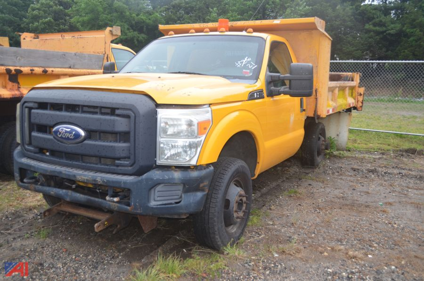 Ford F-350 Super Duty dumped truck in yellow with front grille view and dumping bed, used condition.