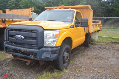 Ford F-350 Super Duty dumped truck in yellow with front grille view and dumping bed, used condition.
