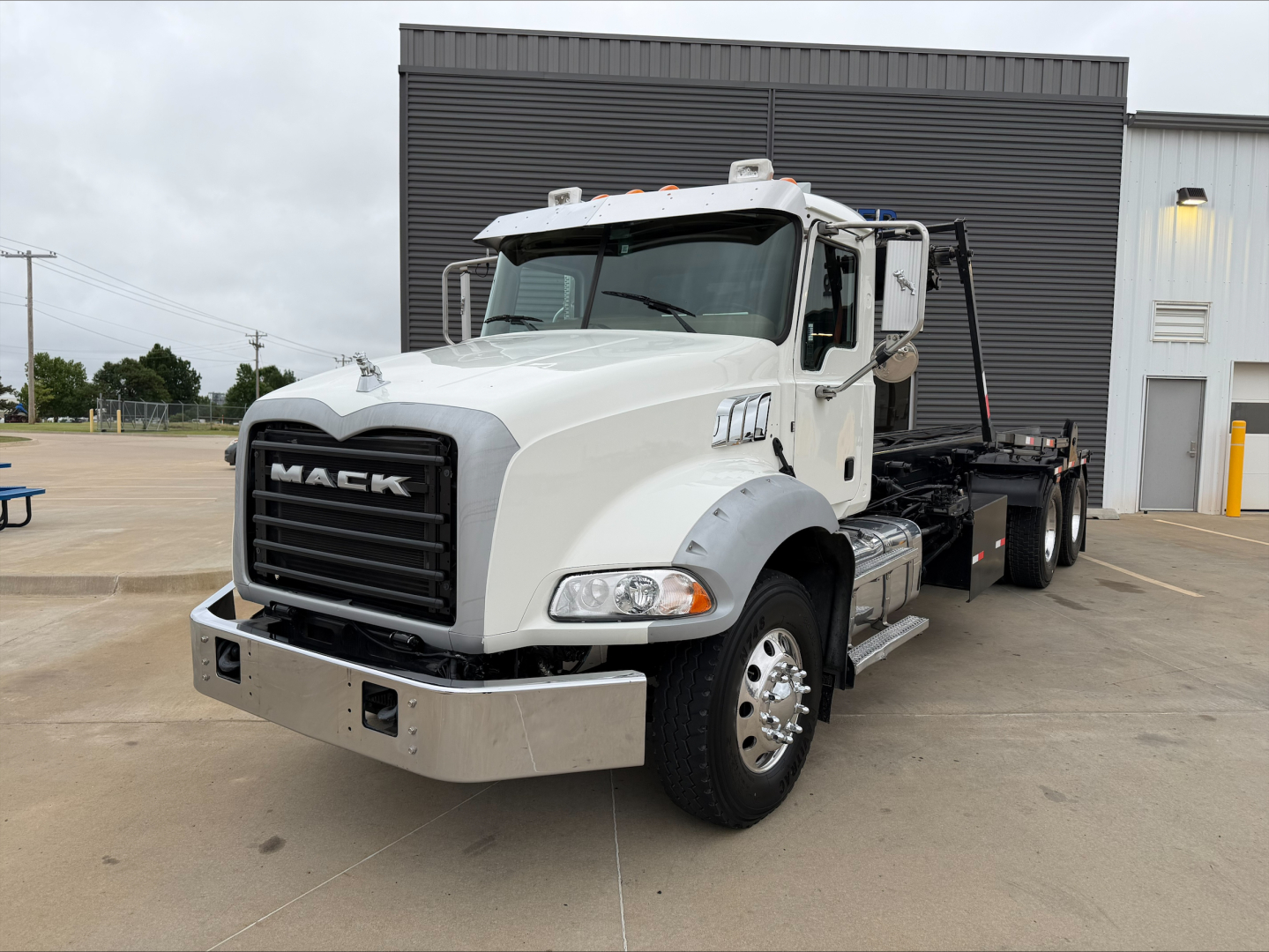 Mack GU533 truck in white, front three-quarter view, with rolloff bed visible, B3202P stock tag, VIN 1M2AX33C8GM010944.