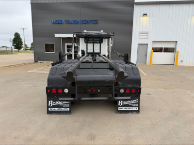 Back view of a 2016 Mack GU533 roll-off truck showing rear lights and bumper area with license plate frames from Oklahoma City.