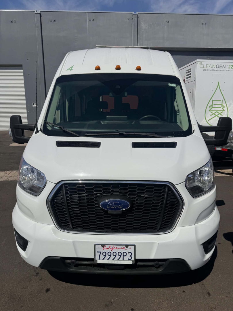 Ford Transit 350 HD XLT front view showing black grille, white body, California license plate 79999P3, dual side mirrors, roof marker lights, and daytime running lights.