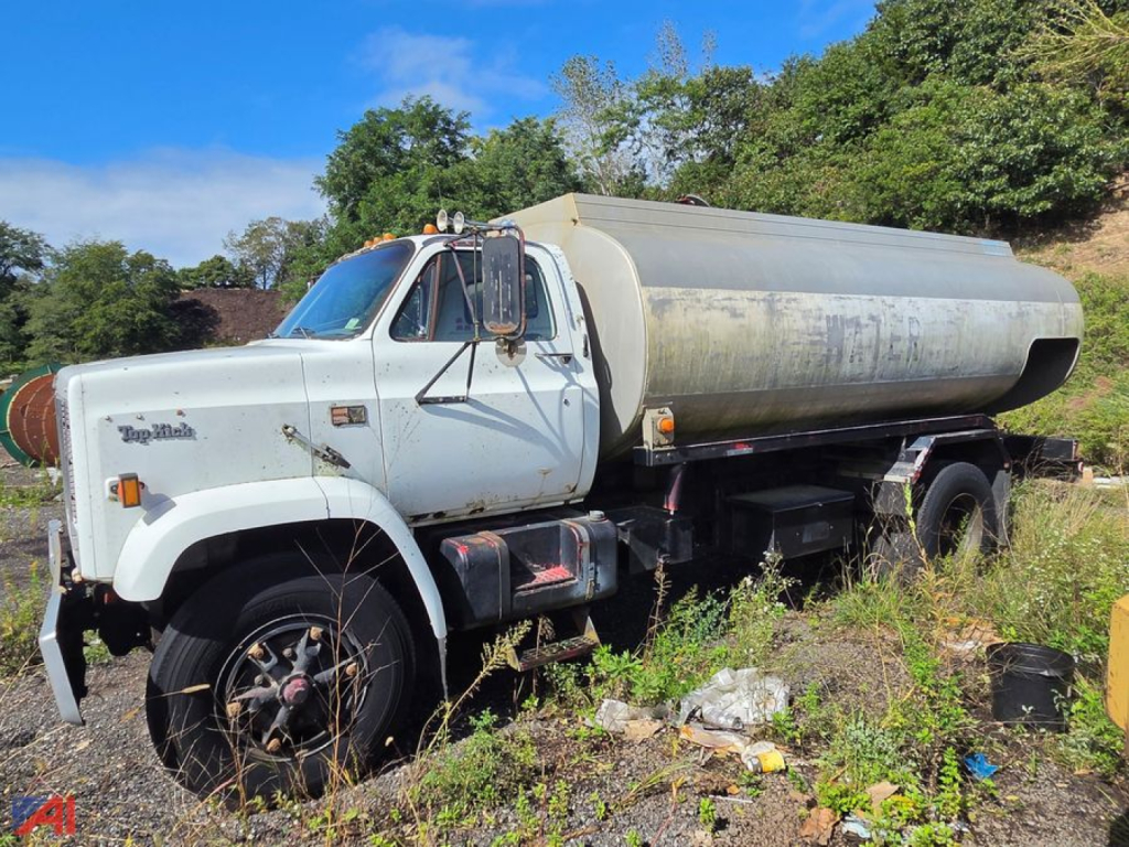 GMC C70 tanker truck side view showing cylindrical metal tank and white cab with dual rear wheels.