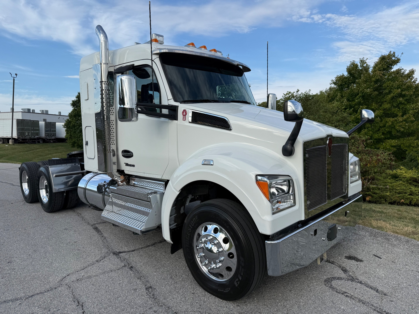 Kenworth T880S truck in white, front-left view showing chrome bumper, dual side mirrors, tall exhaust stacks, and steps.