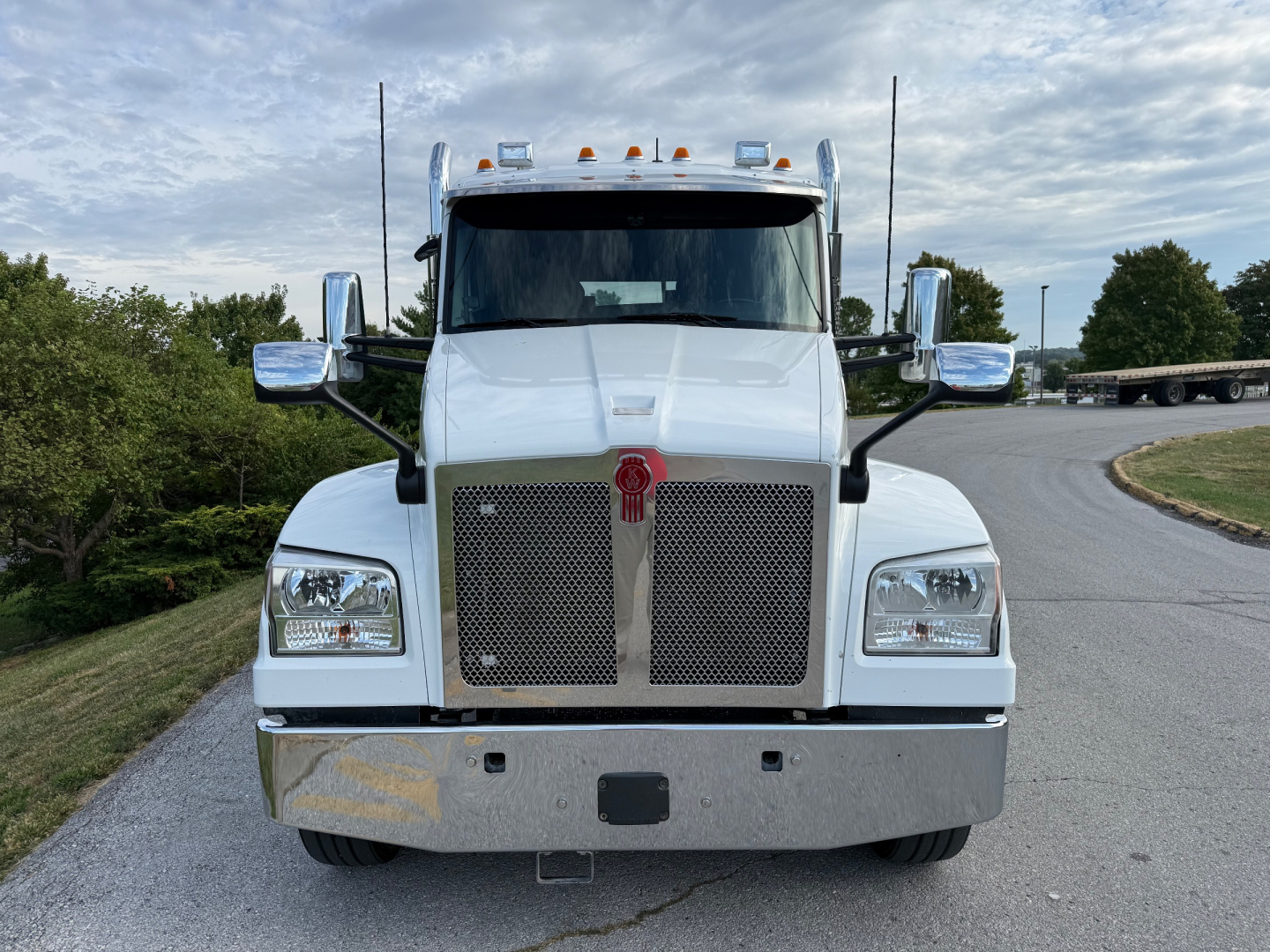 Kenworth T880S front view showing large chrome grille, rectangular headlights, and chrome bumper with Kenworth emblem.