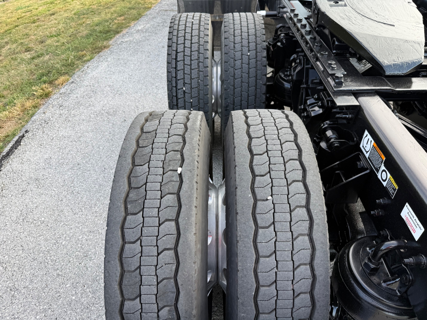 Kenworth T880S truck rear dual rear wheels showing tire treads and chassis components.