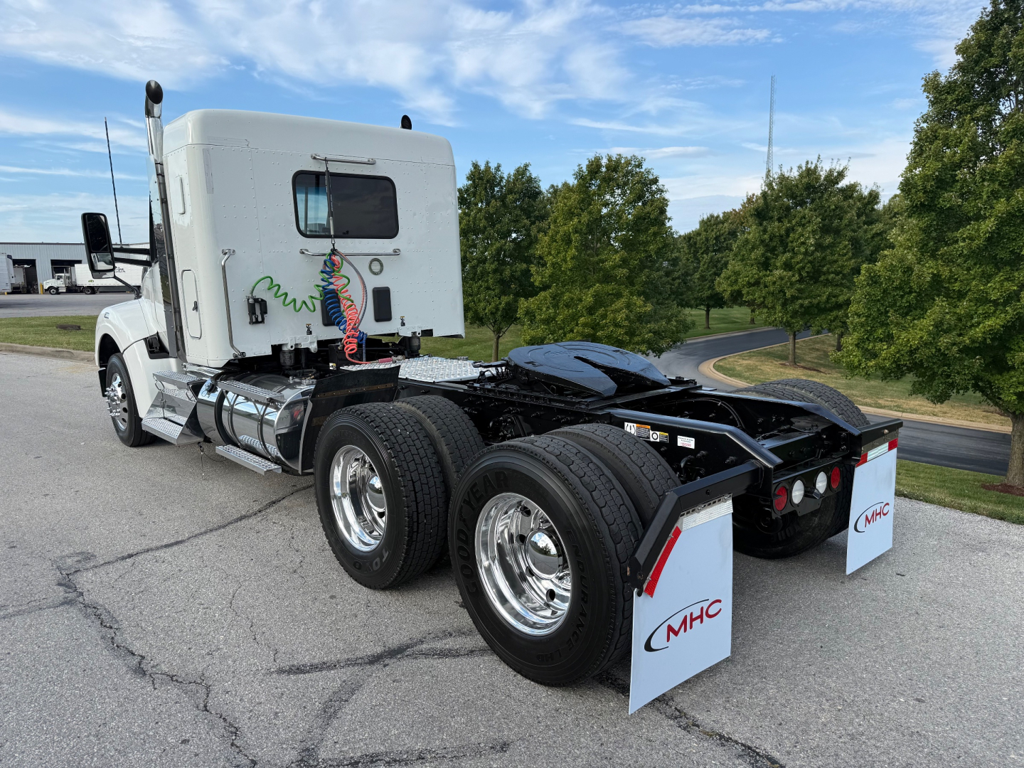 Kenworth T880S tractor in profile view showing rear chassis with dual rear axles and mud flaps, sleeper cab, chrome fuel tanks, and rear air lines.