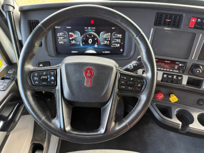 Kenworth T880S interior dash and steering wheel view showing digital gauge cluster and control panels on the dashboard.