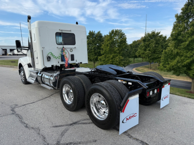 Kenworth T880S tractor in profile view showing rear chassis with dual rear axles and mud flaps, sleeper cab, chrome fuel tanks, and rear air lines.