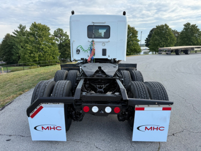 Kenworth T880S truck chassis rear view showing dual rear axles, spare mud flaps with MHC logo, and fifth wheel area.