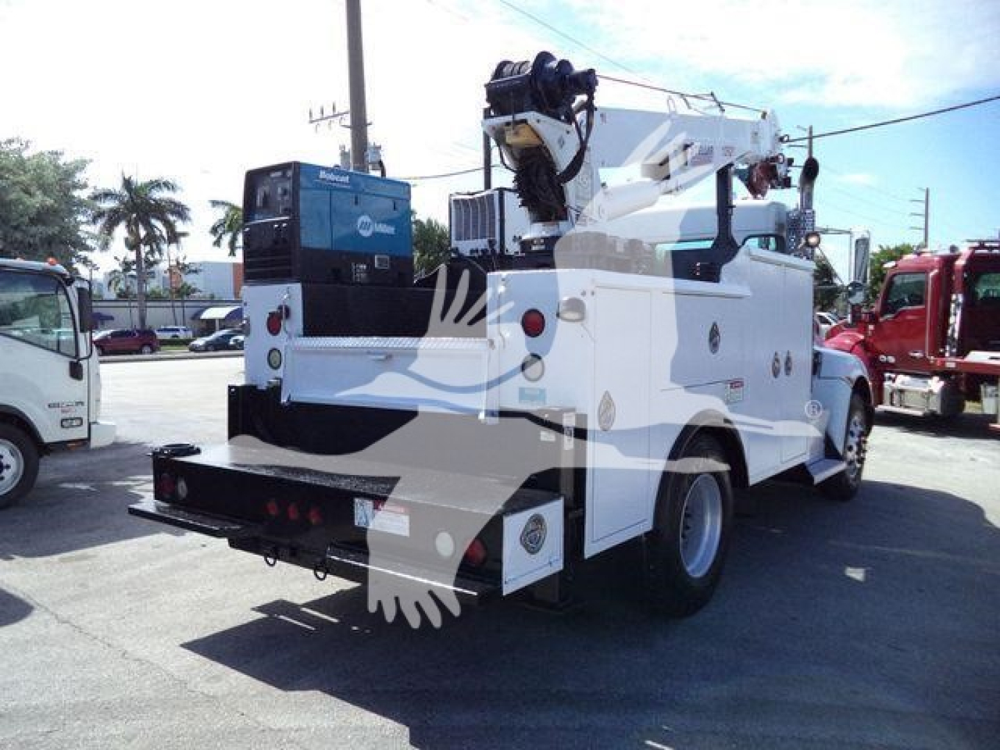 Kenworth service truck rear view showing crane on bed and utility compartments