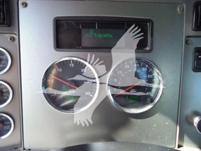 Dashboard with two round gauges and a digital display reading Trip Info. Picture shows Kenworth truck instrument cluster, with rpm and speedometer scales.