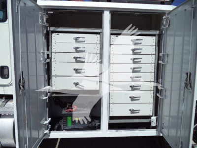 Kenworth T270 service truck rear cargo area with two tall cabinets of drawers and a battery/auxiliary power unit visible at bottom left