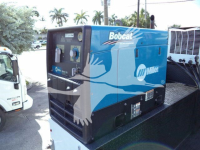 Kenworth/T270 service truck with blue Bobcat Miller logo portable generator on a flatbed, side view showing control panel and branding.