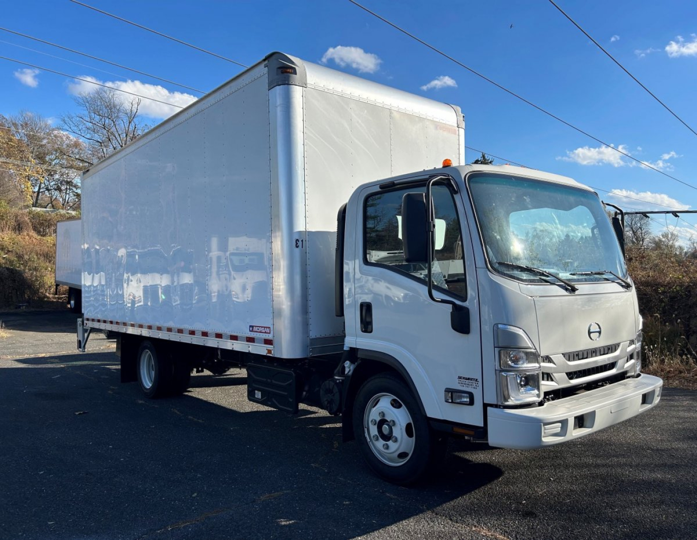 Hino 155 box truck side and front view showing cab, box cargo area, and wheel.
