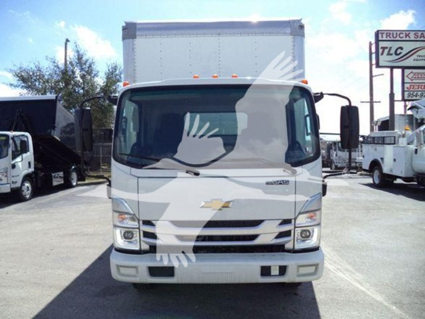 Front view of a white 2023 Isuzu NPR box truck showing Chevrolet-style grille and bumper, large windshield, two side mirrors, and box cargo area.