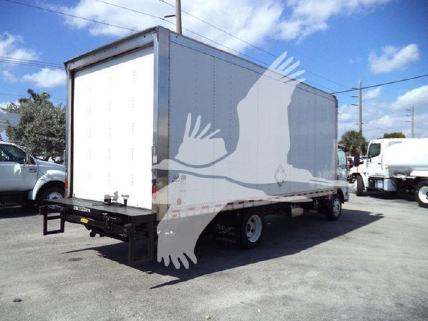 Isuzu NPR box truck rear view showing cargo box and rear bumper with cargo area; a white box body on chassis with dual rear wheels.