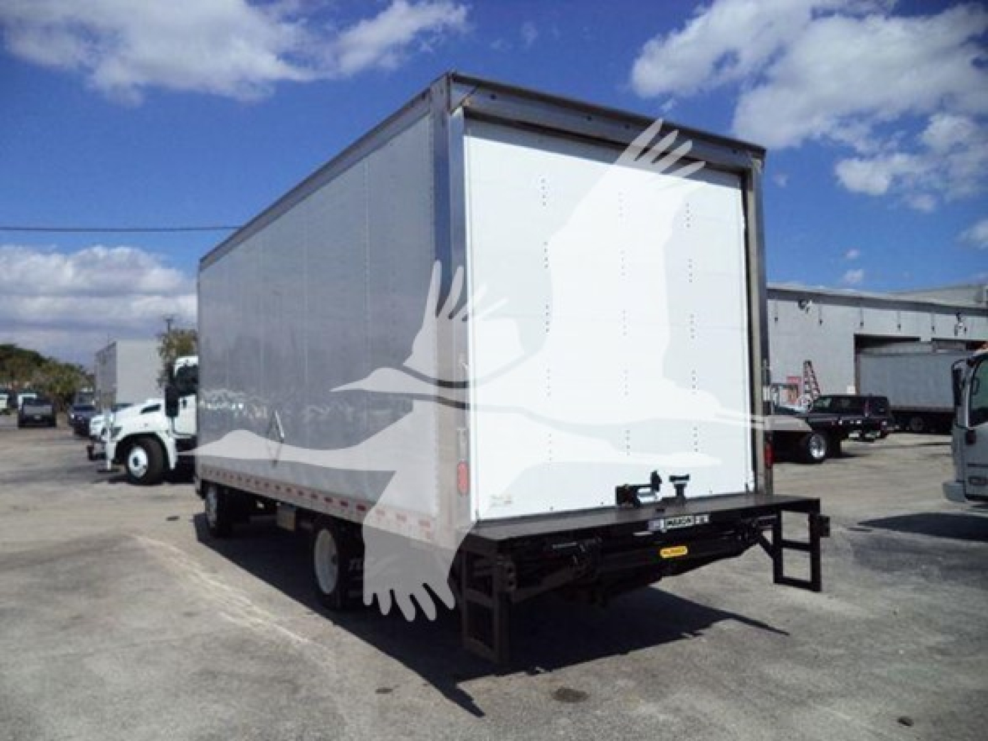 Isuzu NPR box truck rear view showing cargo box and rear bumper with hitch.