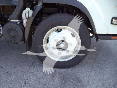 Isuzu NPR front wheel showing Goodyear tire and white steel wheel with five lug nuts.