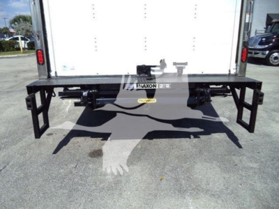 Isuzu NPR rear view showing a black alloy bumper/ladder-style hitch assembly mounted under box; Palaxon brand plate and hooks visible.
