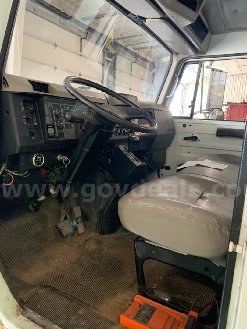 Interior of a 2000 International 4700 cab showing steering wheel and dash area.