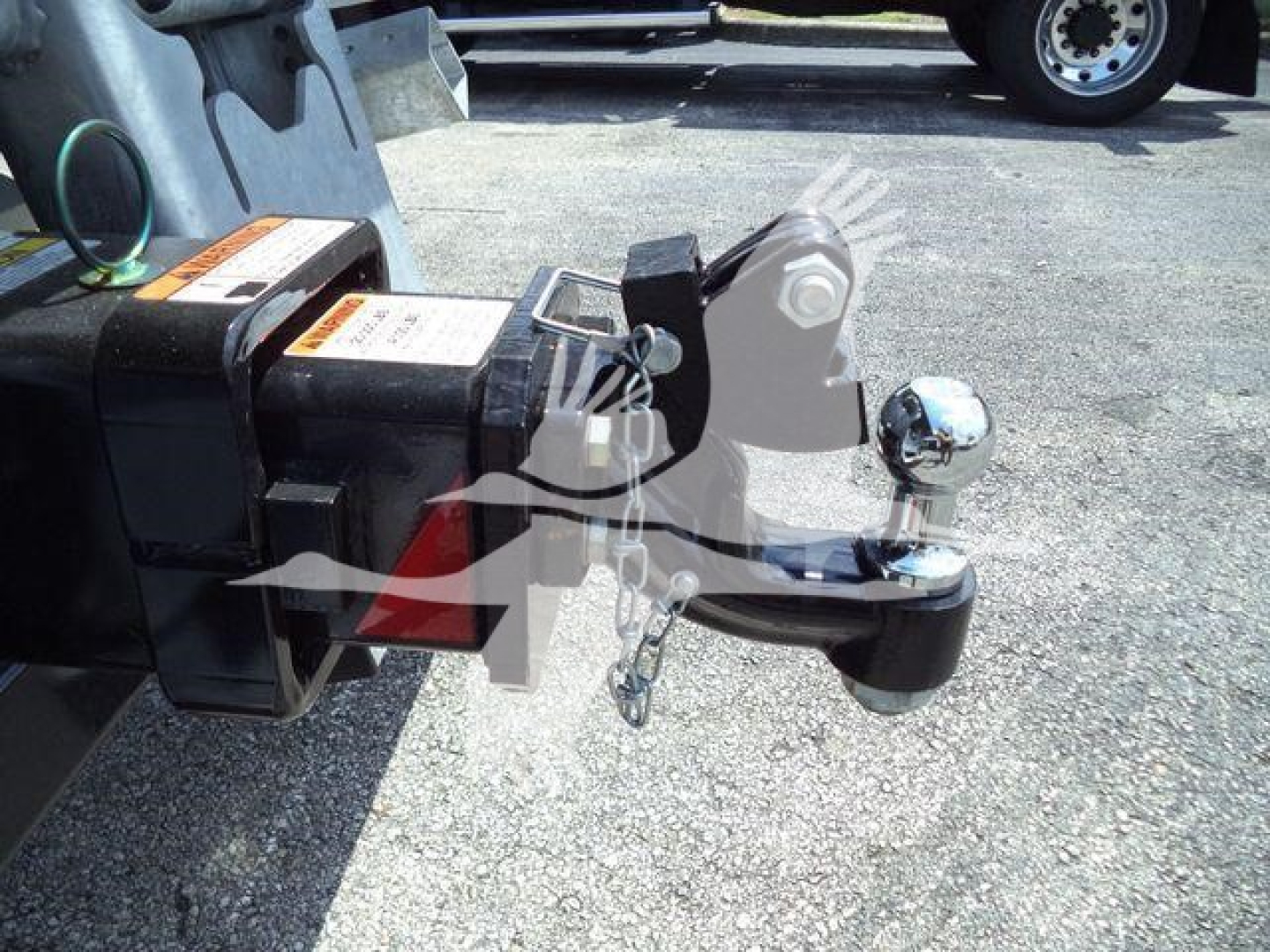 Tow hitch and hitch receiver on a new Kenworth T880 pickup trailer hitch/ball mount with safety chain and electrical connector visible.