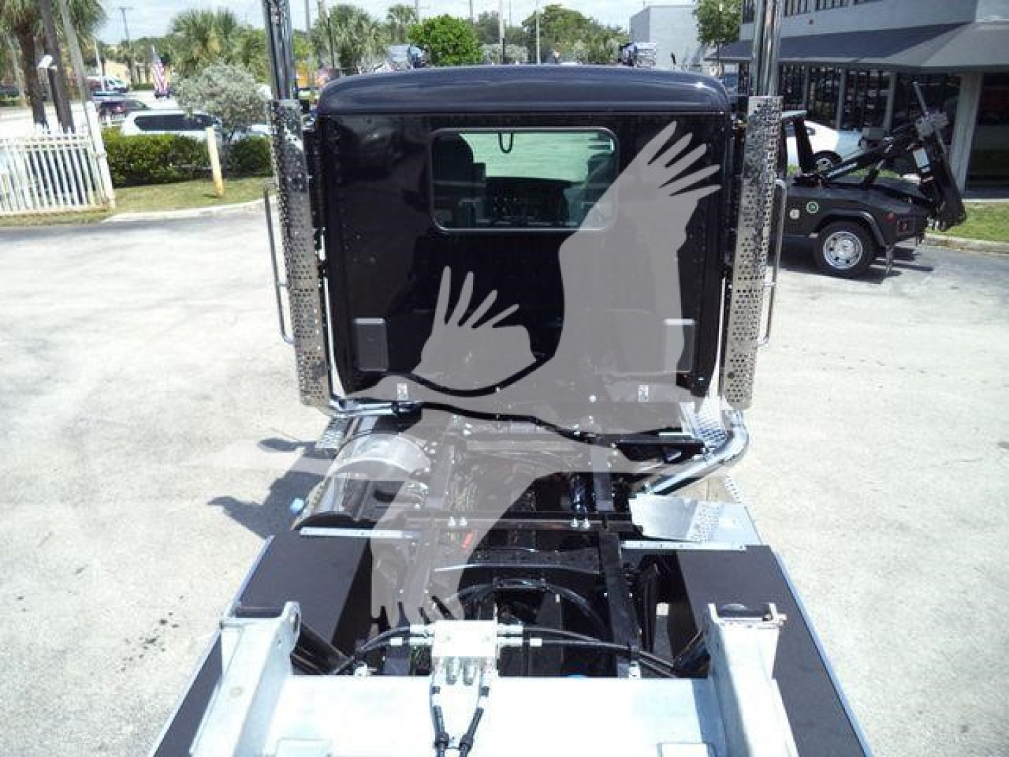 Kenworth T880 truck cab rear view showing black exterior and chrome bumper, dual exhaust stacks, and rear window.