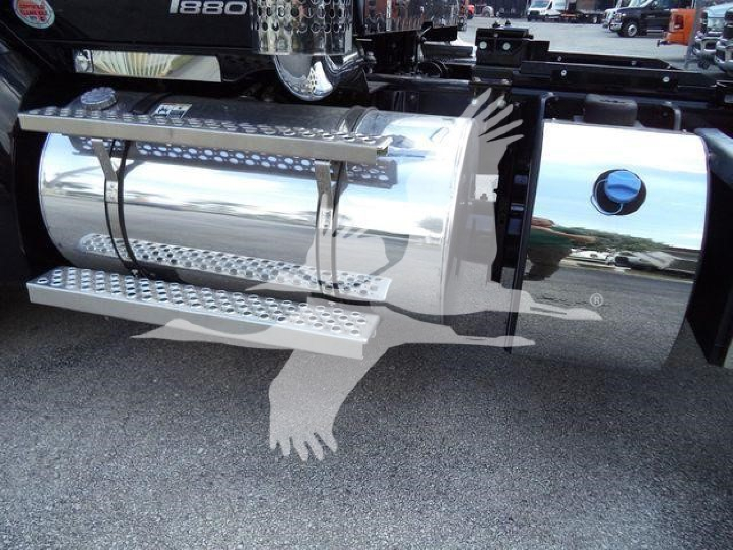 Kenworth T880 rollback truck side with polished chrome fuel tank and side steps visible.
