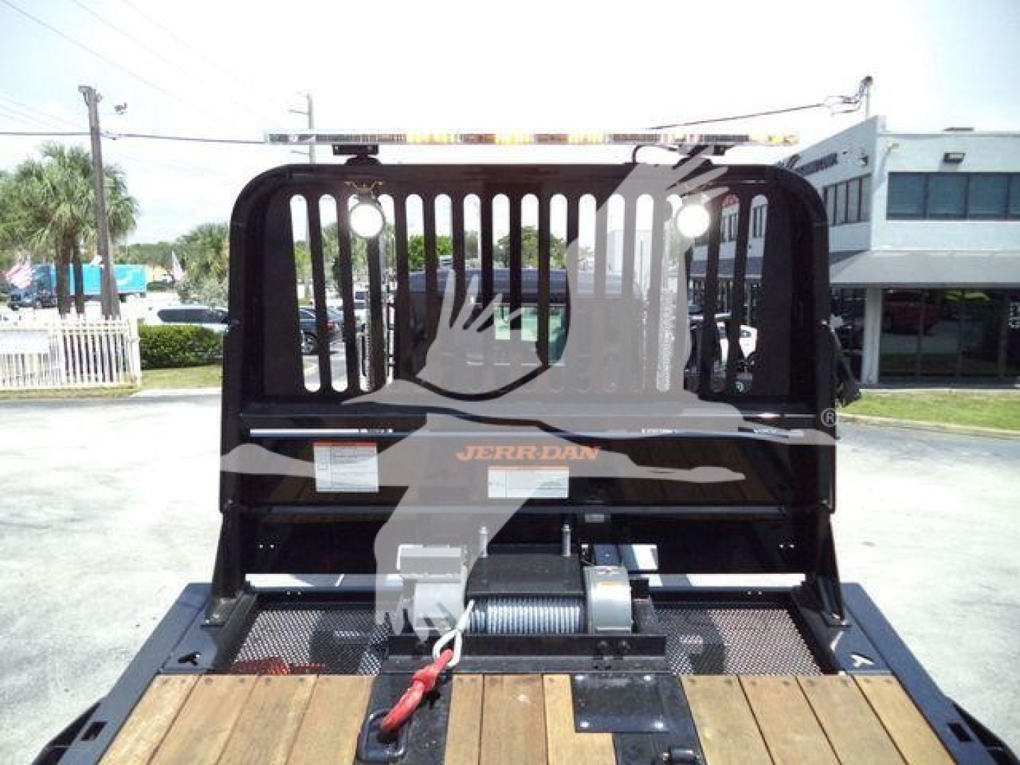 Kenworth rollback truck bed with winch and protective overhead guard, Jerr-Dan branding visible.