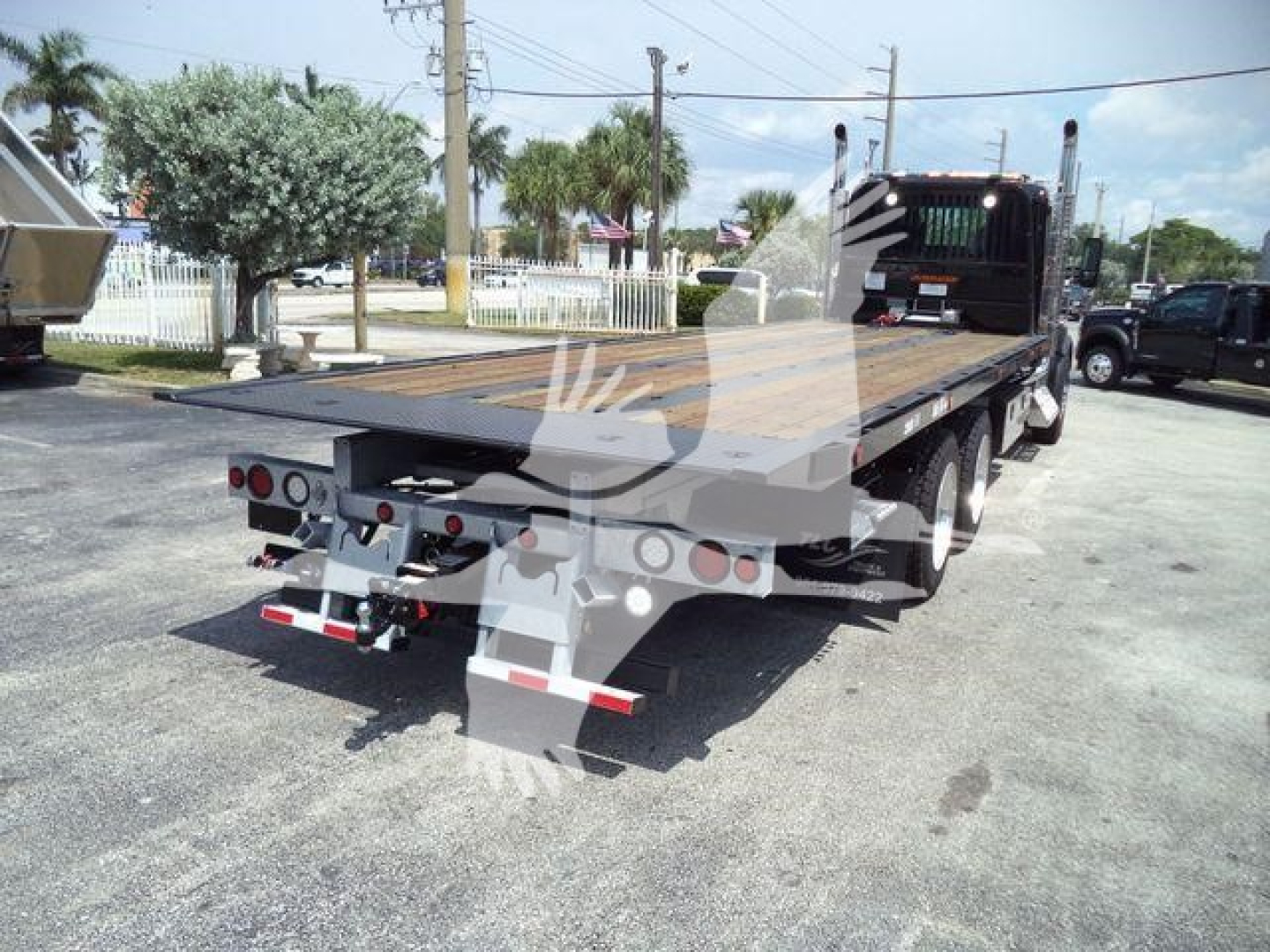 Kenworth T880 rollback truck trailer showing flatbed with rear bumper lights and towing hitch.