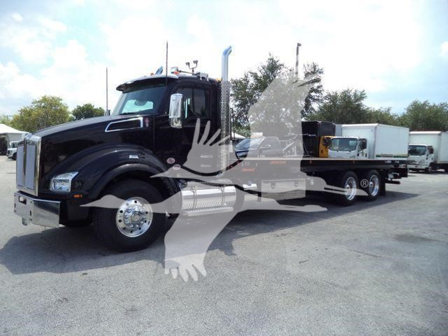 Kenworth T880 rollback truck in showroom view showing cab and trailer chassis with black paint.