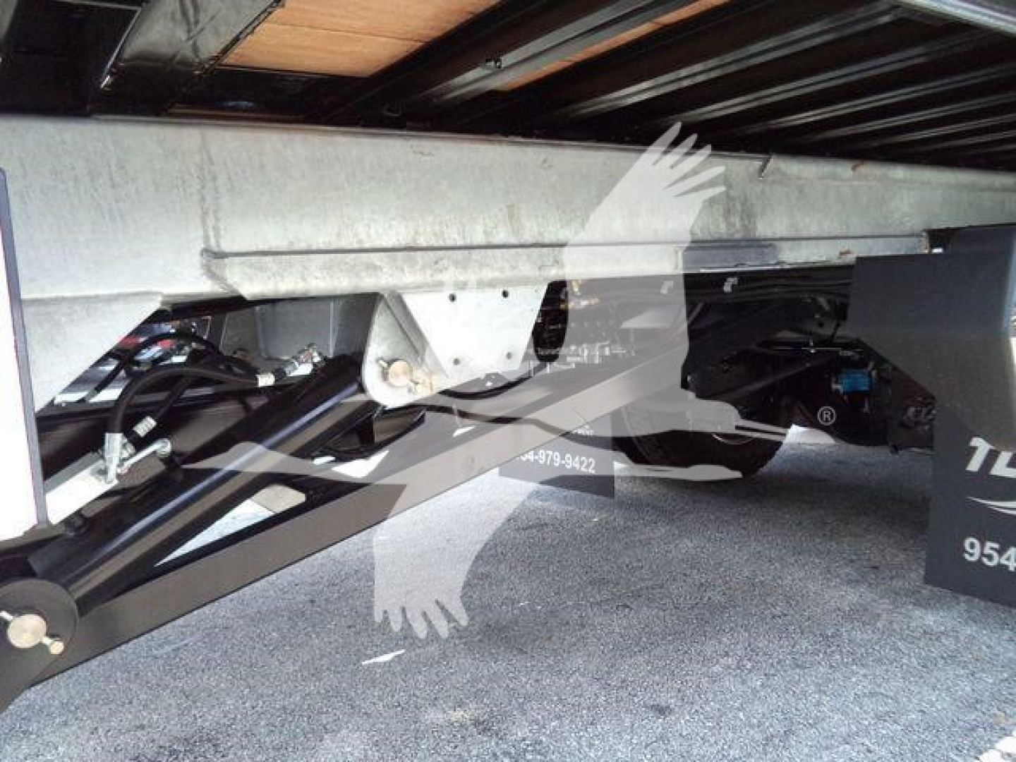 Underbelly view of a 2026 Kenworth T880 rollback truck showing chassis and hydraulic components.
