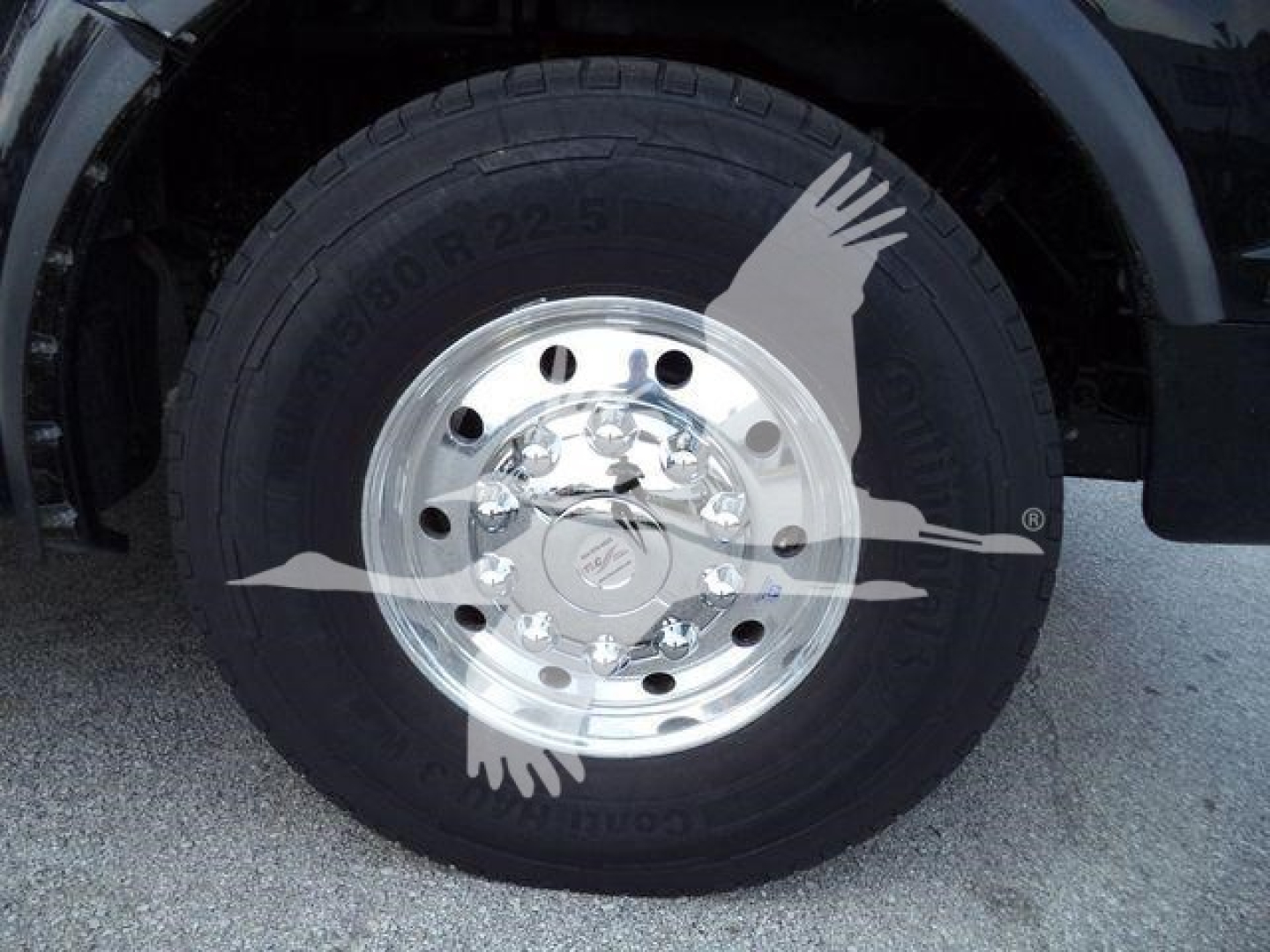 Truck wheel with polished aluminum rim and black tire in-view