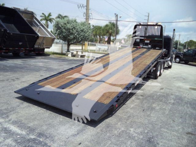 Truck rollback bed with wooden decking and ramps, Kenworth T880 setup on trailer.