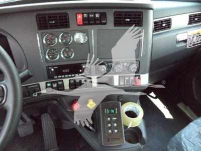 Kenworth T880 dash area showing gauge cluster and column controls with cup holder and gear selector in view.