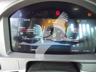 Dashboard display of a Kenworth T880 instrument cluster showing digital gauges, fuel level, and warning icons.