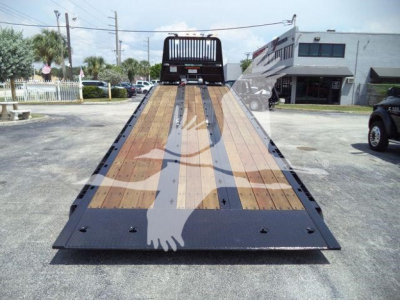 Kenworth T880 rollback tow truck flatbed viewed from rear, wood deck platform with metal reinforcements and ramp at back.