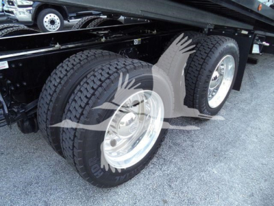 Kenworth T880 rollback truck wheel area showing tandem rear dual tires and suspension undercarriage.