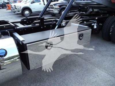 Kenworth T880 rollback truck frame with a large rectangular metal toolbox mounted under the cab, visible suspension and frame rails in background.
