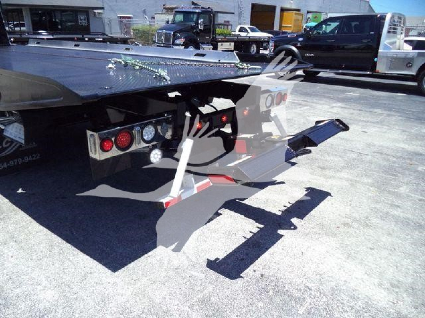 Rear of 2025 Kenworth T280 rollback truck showing tail lights, towing apparatus, and hydraulic wheel-lift platform.