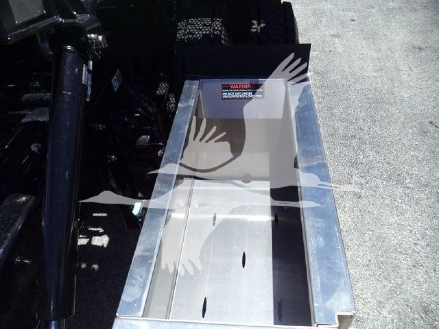Kenworth T280 rollback truck bed view showing metal cargo bed with warning label and side rails.