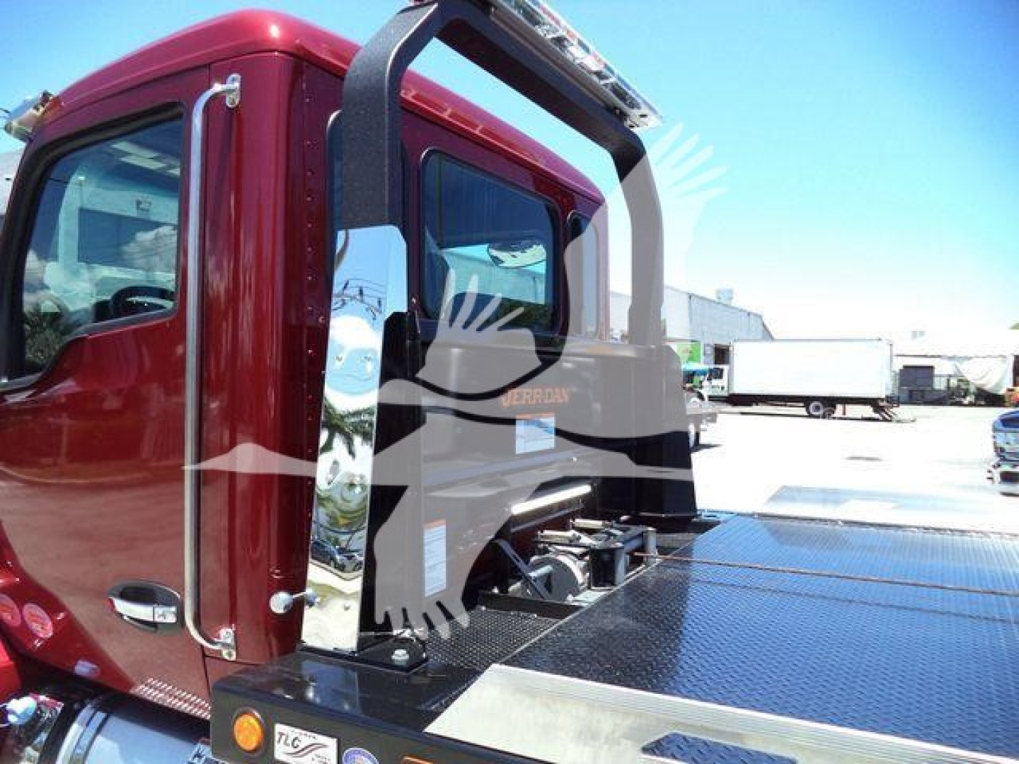 Kenworth T280 rollback truck cab and flatbed area with chrome steps and rear operator rail, maroon cab, metal diamond plate surface.