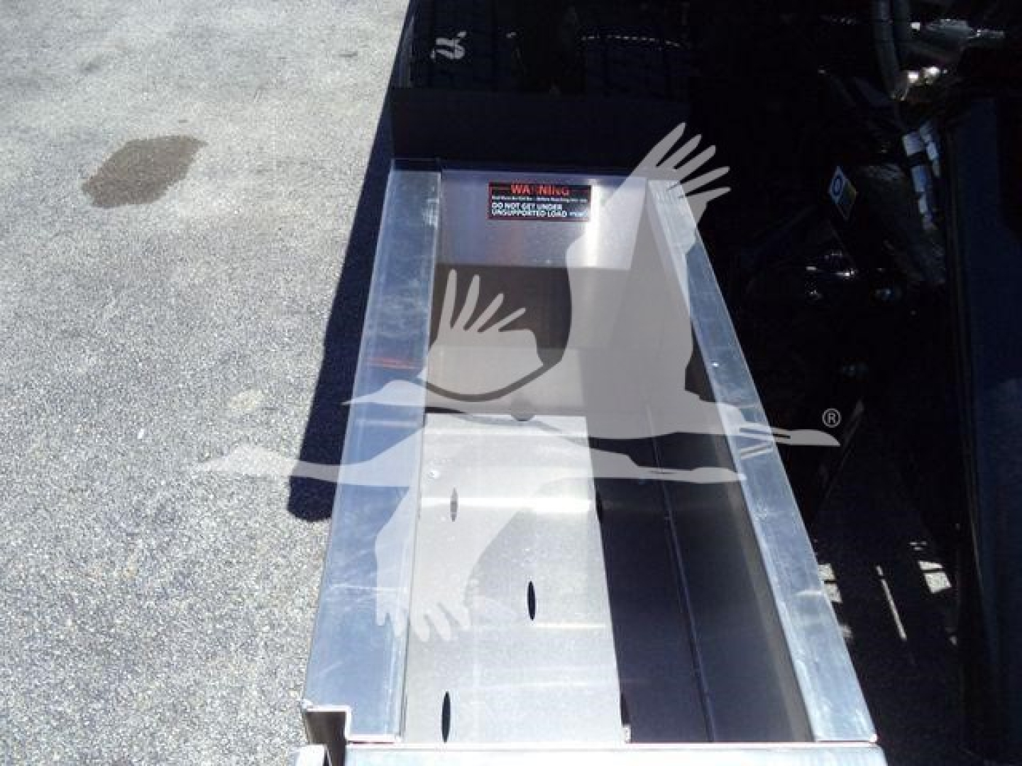 Kenworth T280 rollback truck bed showing metal toolbox/step area with bolts and warning label visible.