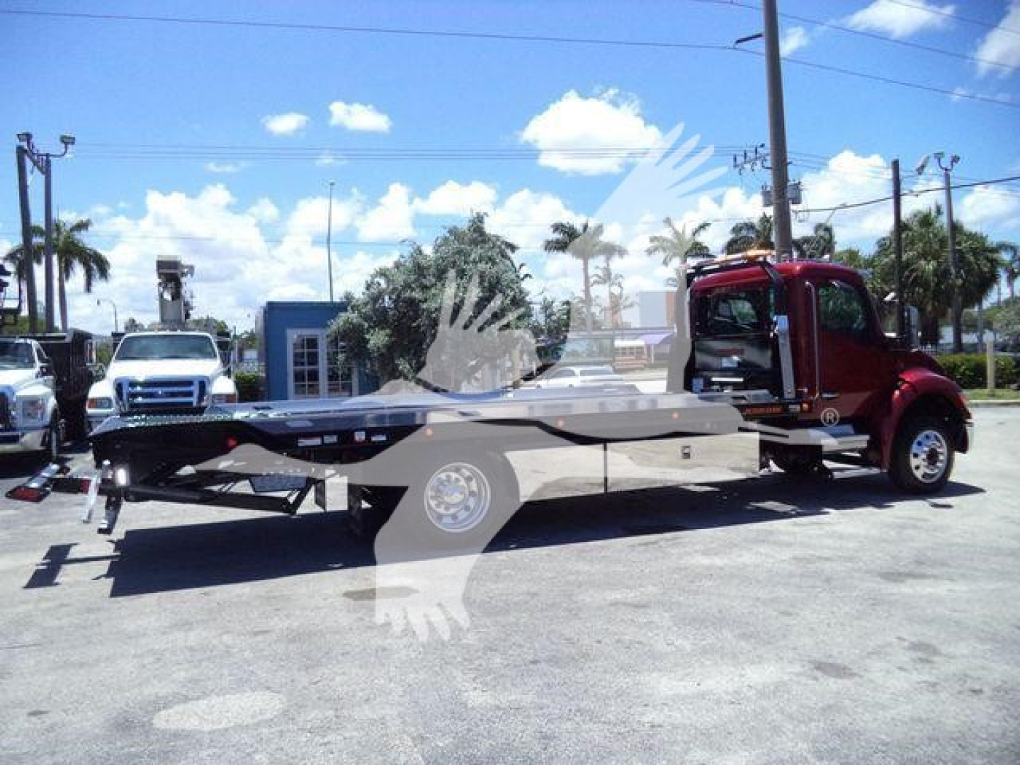 Kenworth T280 rollback truck with flatbed tow body and red cab in a dealership lot, stock number KWT280XLP22BURG visible.