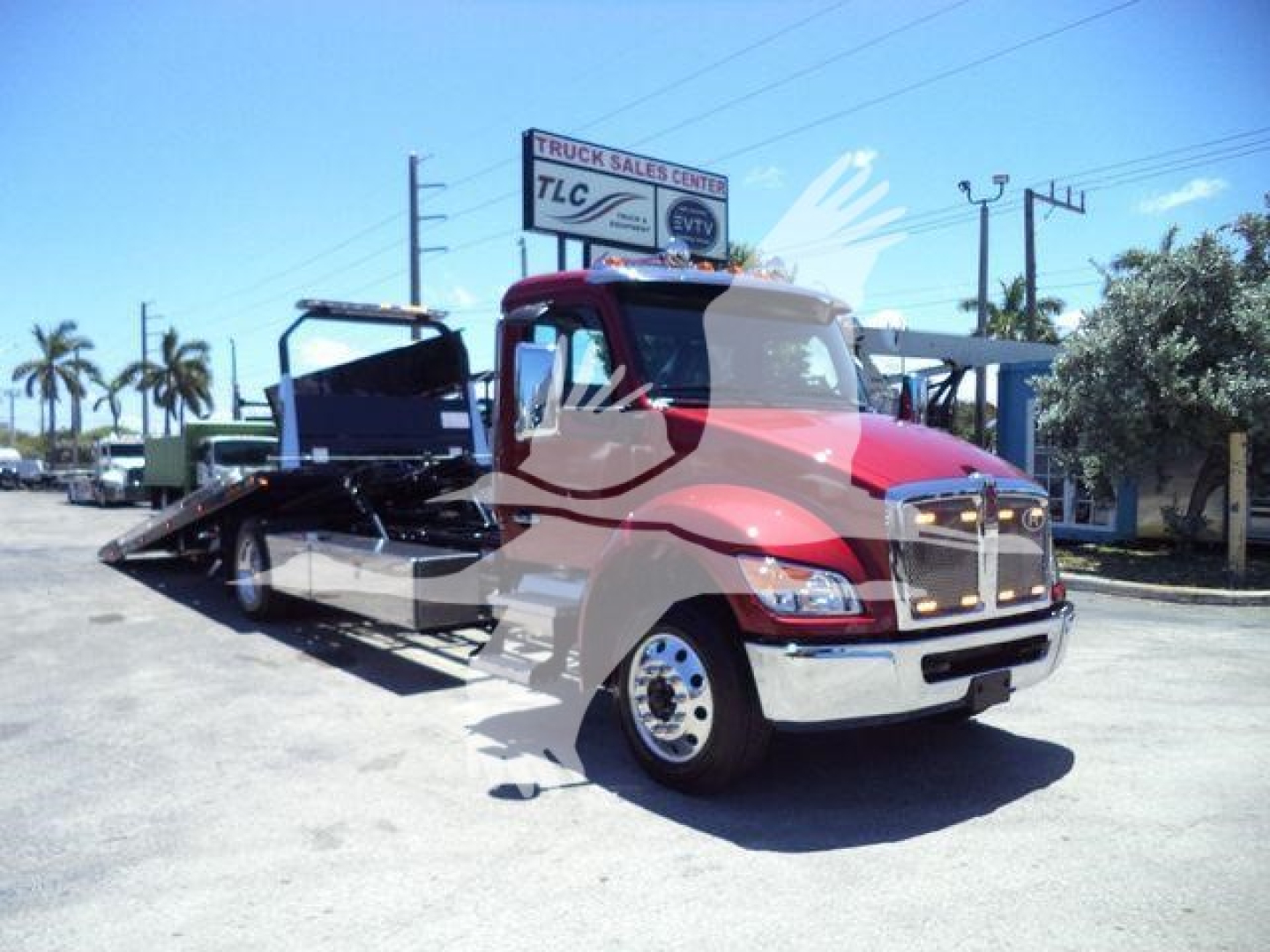 Kenworth T280 rollback truck in red and chrome, front view, with flatbed ramp extended.