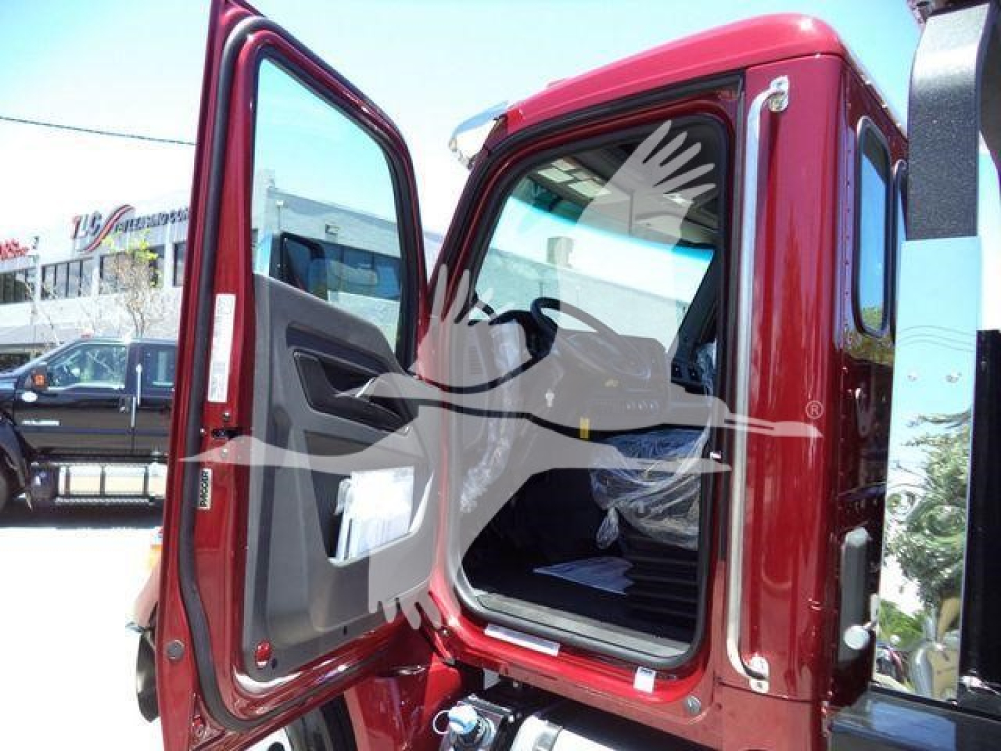 Truck cab interior and open door showing Kenworth T280 dashboard area and entry; appears to be a red new rollback truck.