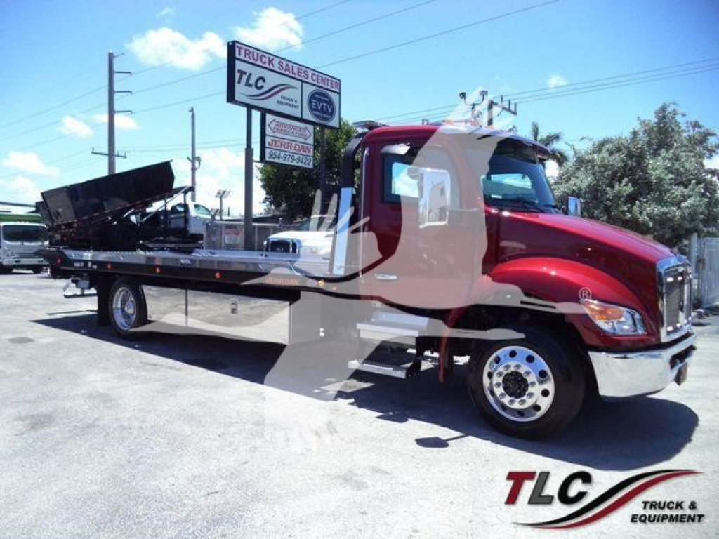 Kenworth T280 rollback truck in red cab with flatbed and hydraulic wheel-lift, front angled view showing wheel rims and side mirrors.