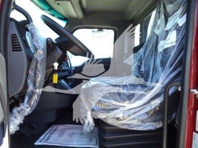 Kenworth T280 truck cab interior with plastic-covered seat and plastic-wrapped controls visible, steering wheel, dashboard and passenger area.