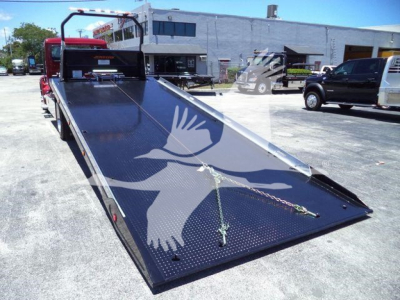 Flatbed rollback truck bed on a new Kenworth T280, with a black perforated steel surface and chains securing the load area.背-front view of the bed.