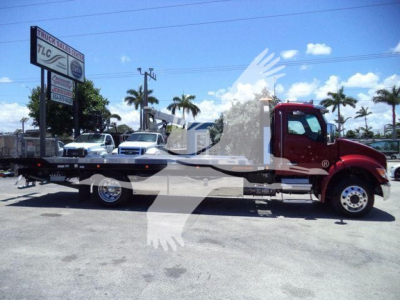 Kenworth T280 rollback tow truck side view showing long flatbed and red cab.