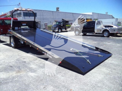 Kenworth T280 rollback truck bed, low-angle view showing loading ramp and hydraulic lines.
